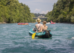 Foto: Schlauchboot-Kanu und gelber Paddel auf der Aare mit einem jungen Paar.