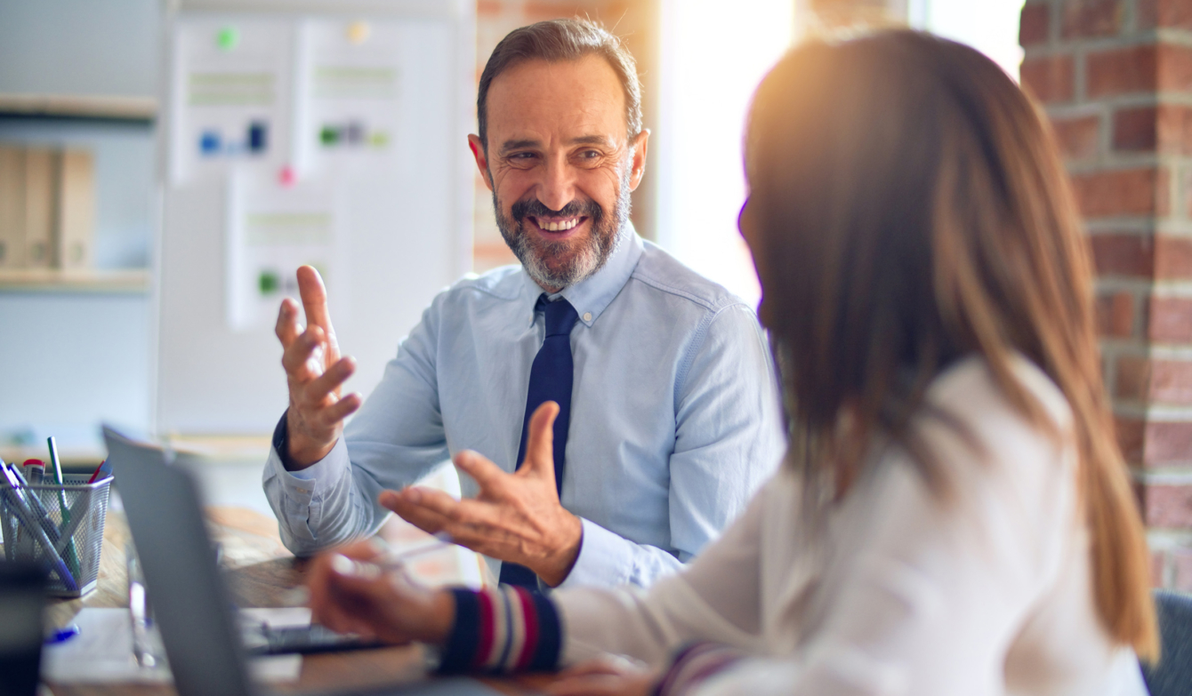 Kollege und Kollegin unterhalten sich im Büro.