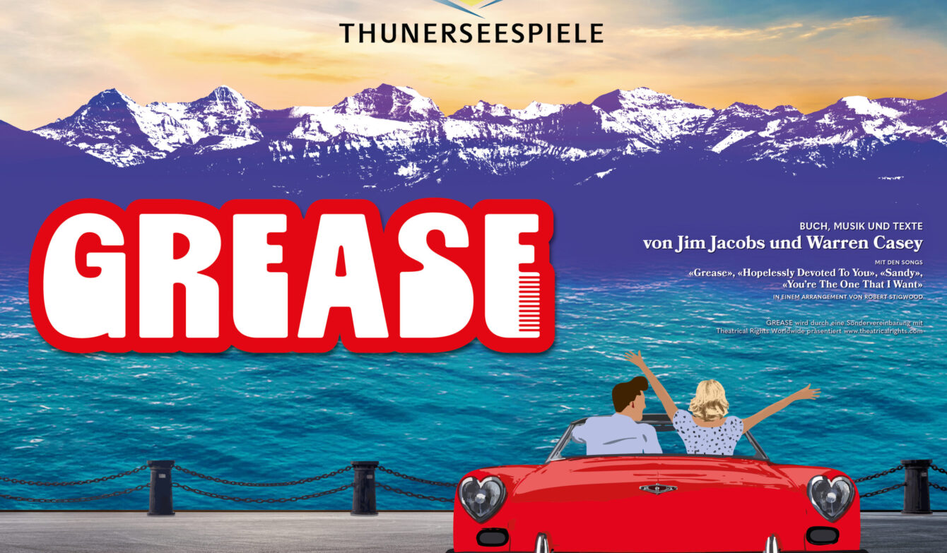 Im Vordergrund steht ein rotes Cabriolet, von hinten zu sehen. Darin sitzen zwei Personen, die fröhlich die Arme heben, als würden sie den Moment feiern. Vor ihnen glitzert der Thunersee in kräftigem Türkis. Dahinter ragen die verschneiten Alpen in die Höhe, violett getönt wie ein Bühnenhintergrund kurz vor der Premiere. Oben im Bild prangt das Logo der Thunerseespiele. Links steht gross ‹GREASE› in roter Schrift mit einem stilisierten Kamm. Die Szene wirkt wie ein Versprechen auf Sommer, Musik und eine Prise Rock’n’Roll.