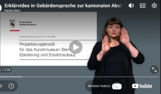 Screenshot eines Erklärvideos des Kantons Bern zur kantonalen Abstimmung vom 14. Juni 2026. Rechts im Bild steht eine Gebärdensprachdolmetscherin vor dunkelgrauem Hintergrund und übersetzt den Inhalt in Gebärdensprache. Sie trägt dunkle Kleidung und ist mit erhobenen Händen mitten in einer Gebärde zu sehen. Links ist die eingeblendete Titelfolie des Videos sichtbar mit dem Logo des Kantons Bern und dem Titel «Projektierungskredit für das Kunstmuseum Bern (Sanierung und Ersatzneubau)». Oben ist die Videoüberschrift «Erklärvideo in Gebärdensprache zur kantonalen Abstimmung» eingeblendet. Unten sind die typischen Bedienelemente eines YouTube-Videos mit Fortschrittsanzeige sichtbar.